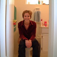 Sitting On Toilet - Jeans, Looking At The Camera , Sitting On Toilet, Pants Pulled Down, Smiling Into Camera, Short Brunette Hair, Looking At Camera, Blue Jeans, Red Blouse